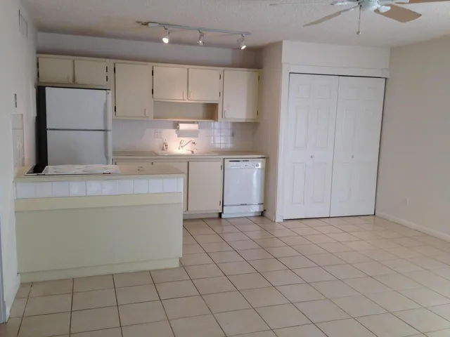 a kitchen with white cabinets and white appliances
