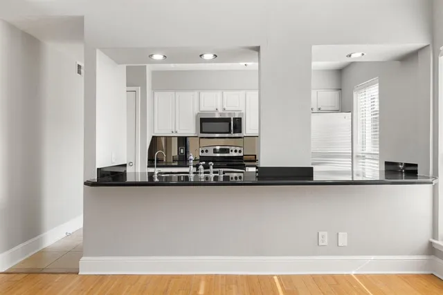a kitchen with stainless steel appliances a sink a stove and cabinets