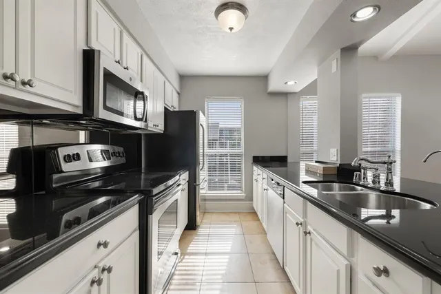a kitchen with a sink and a large mirror