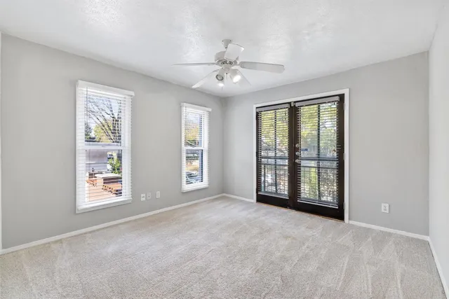 an empty room with windows and cabinet