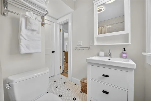 a spacious bedroom with a large bed and a chandelier