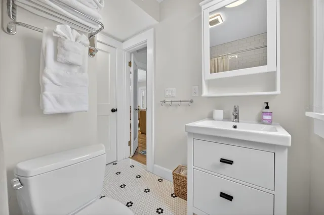 a spacious bedroom with a large bed and a chandelier