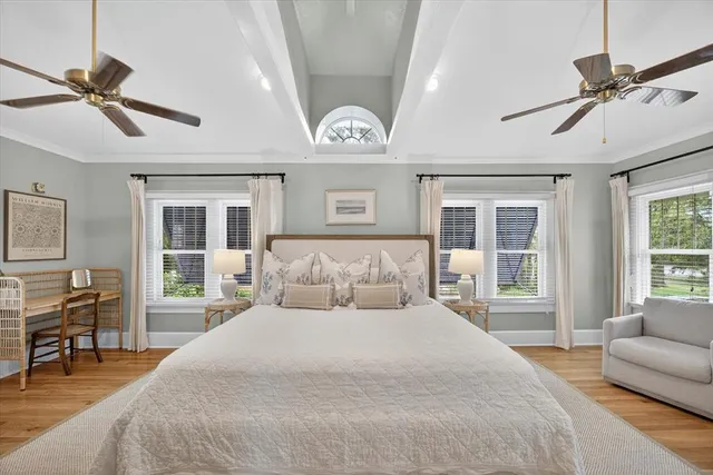 a spacious bedroom with a large bed and a chandelier
