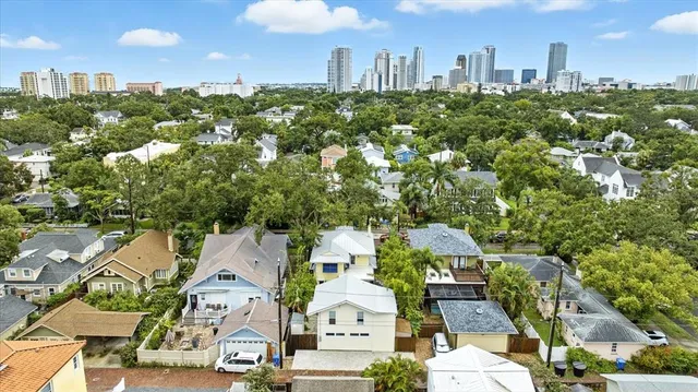 an aerial view of residential houses with outdoor space and trees