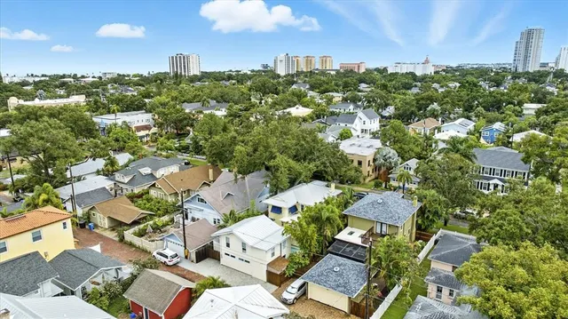 an aerial view of residential houses with outdoor space and trees