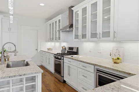 a kitchen with stainless steel appliances granite countertop a sink stove and cabinets