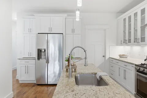 a kitchen with stainless steel appliances granite countertop a refrigerator sink and stove