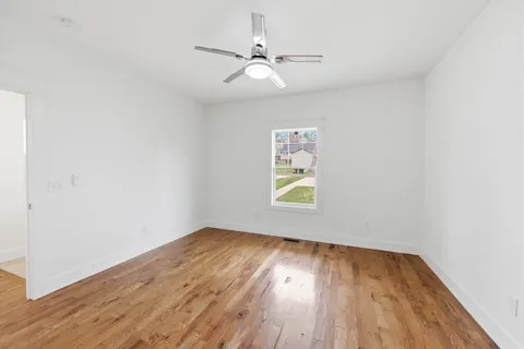 an empty room with a window and wooden floor
