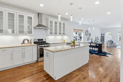 a kitchen with stainless steel appliances granite countertop a lot of counter space and wooden floors
