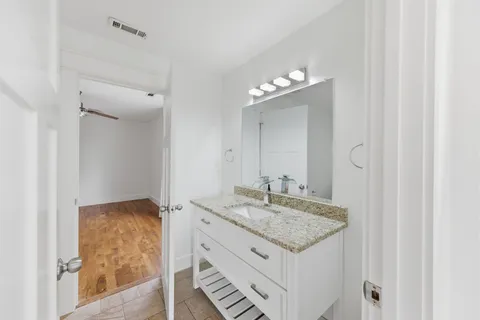 a bathroom with a granite countertop sink and a mirror