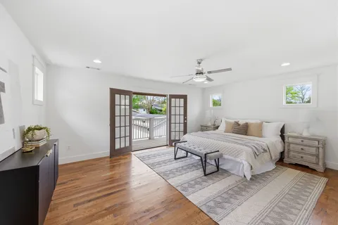 a spacious bedroom with a bed and wooden floor