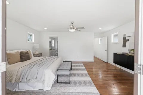 a large bedroom with a bed and wooden floor