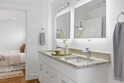 a bathroom with a granite countertop sink and a mirror