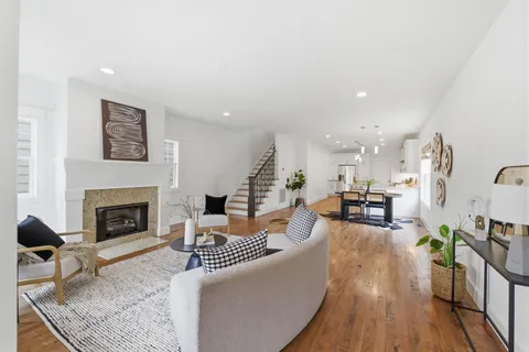 a living room with furniture fireplace and wooden floor