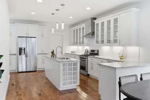 a kitchen with stainless steel appliances granite countertop a sink stove and refrigerator