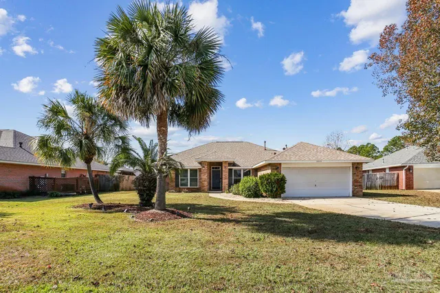a front view of a house with a garden and tree