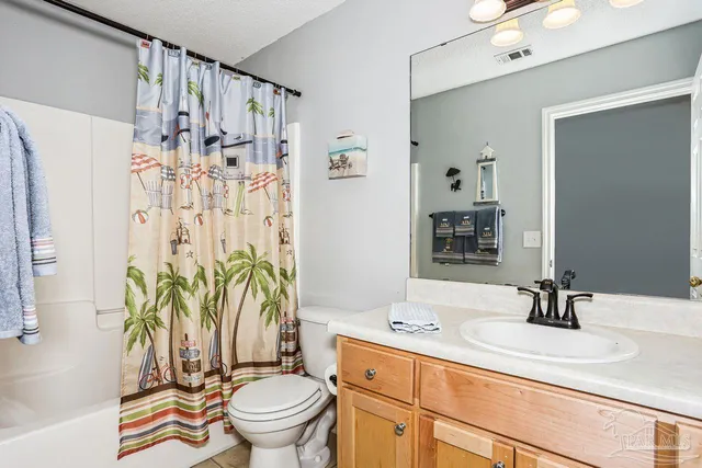 a bathroom with a sink a toilet and shower curtain