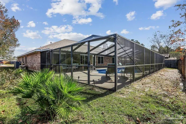 a view of a house with backyard and sitting area