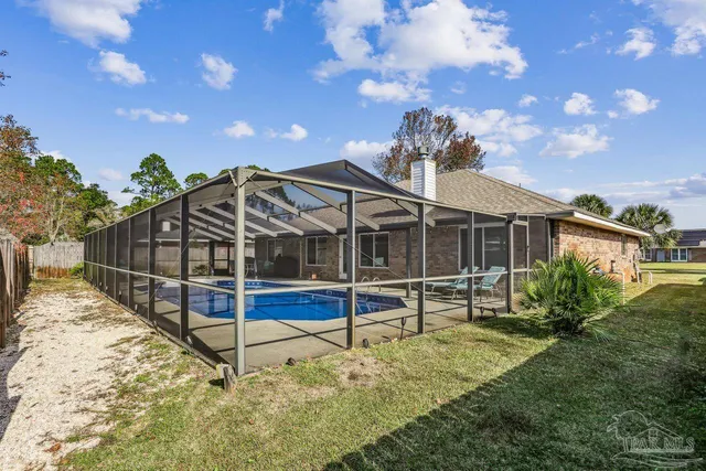 a view of a house with a yard and wooden fence
