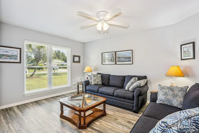 a living room with furniture a table and a large window