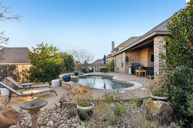 a view of a swimming pool with a patio and fire pit