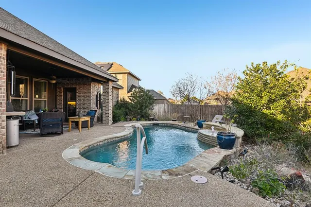 a view of house and patio with swimming pool