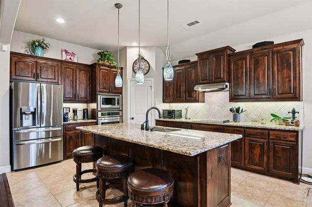 a kitchen with stainless steel appliances granite countertop a sink stove and refrigerator