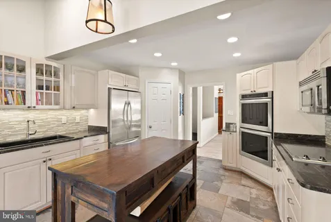 a kitchen with granite countertop a stove refrigerator and microwave