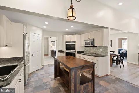 a large kitchen with a table and chairs in it