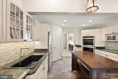 a kitchen with a sink stainless steel appliances and cabinets