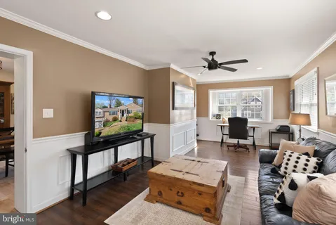 a living room with furniture a window and a flat screen tv