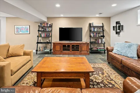a living room with stainless steel appliances furniture and a flat screen tv