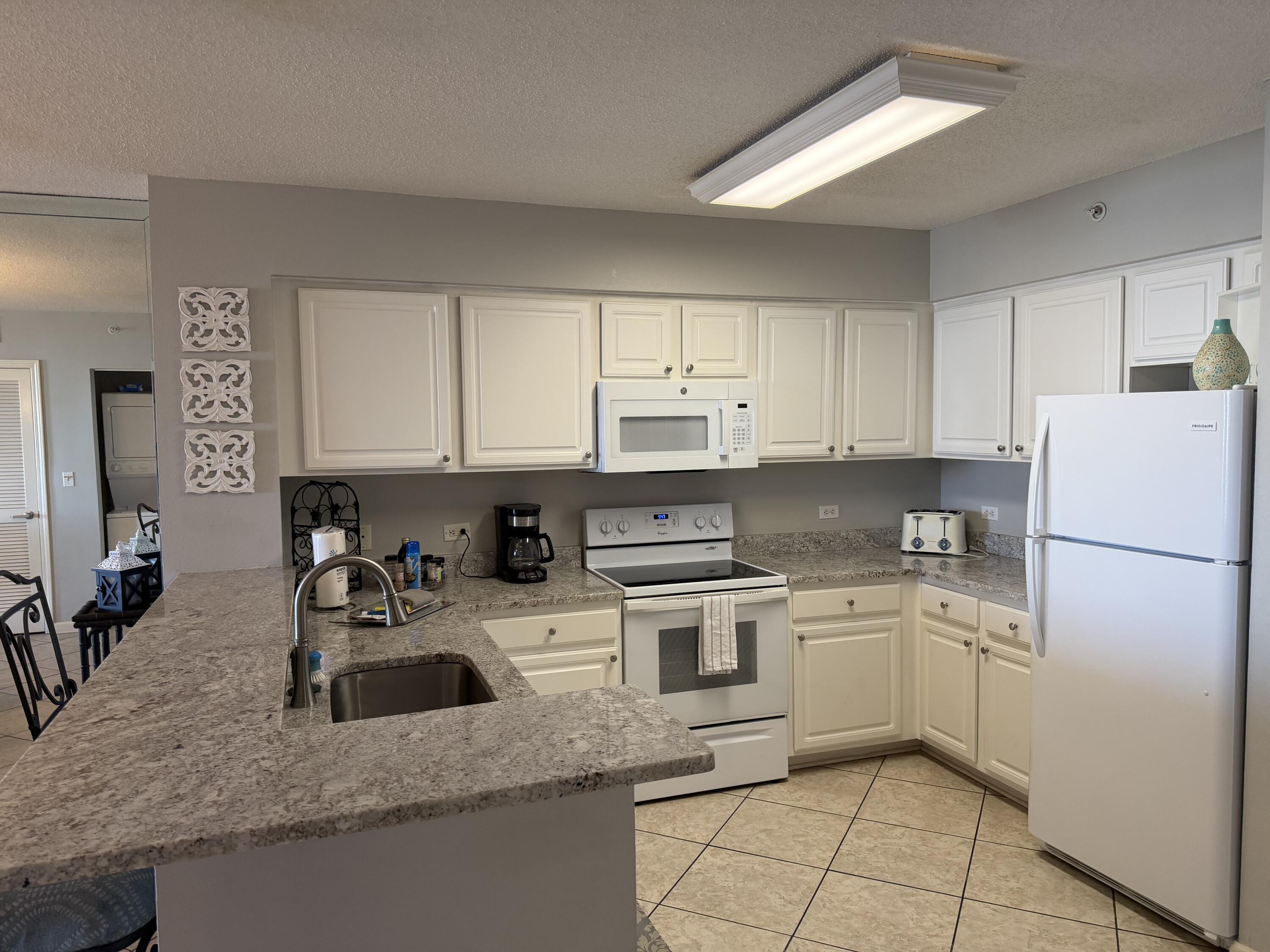 970 Highway 98, Unit 602 Destin, FL 32541 - Photo 3 of 18 a kitchen with stainless steel appliances granite countertop a sink stove and refrigerator