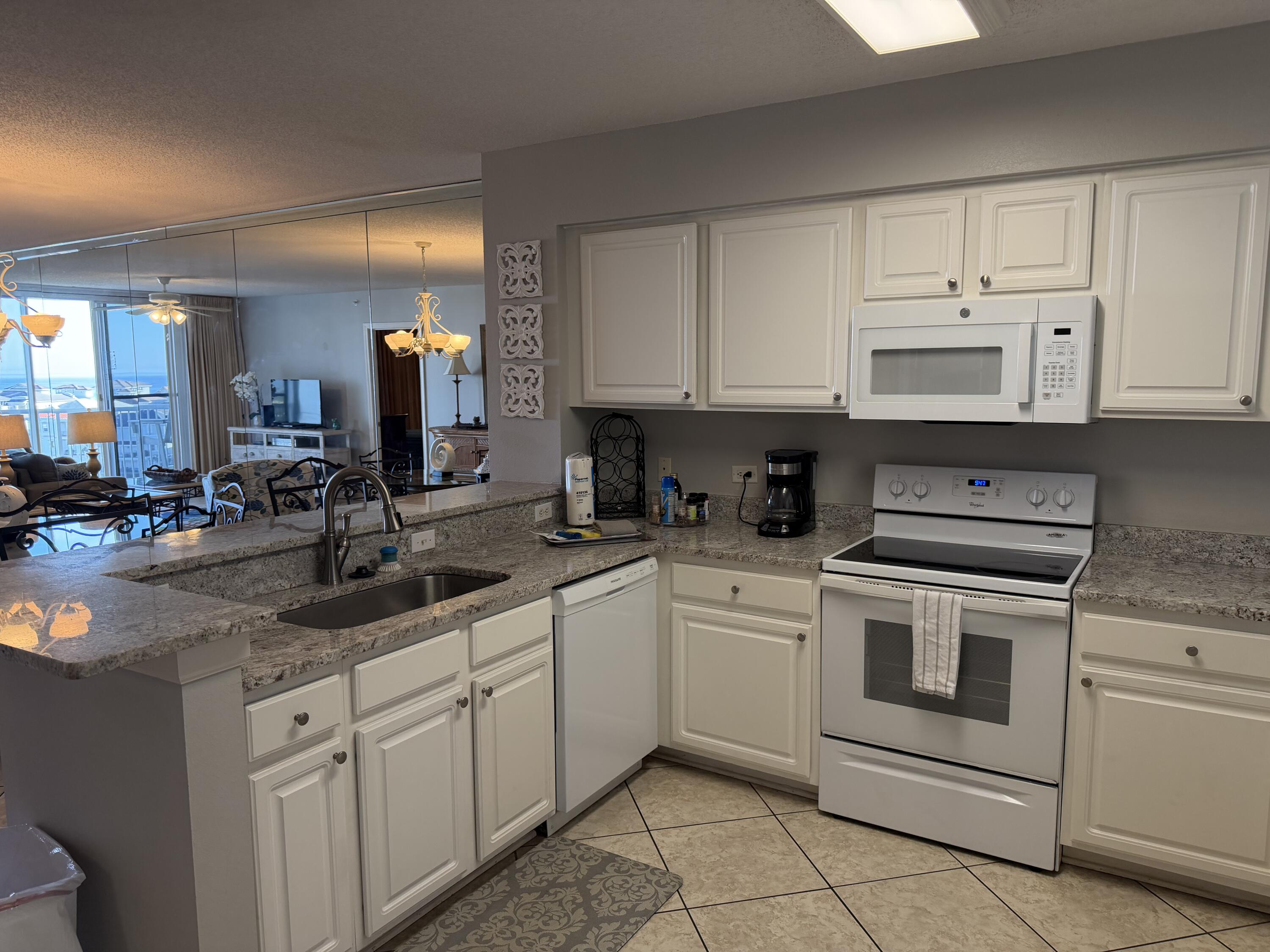 970 Highway 98, Unit 602 Destin, FL 32541 - Photo 4 of 18 a kitchen with white cabinets appliances and a sink