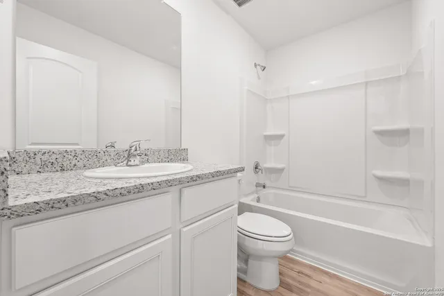a bathroom with a granite countertop toilet a sink and a bathtub