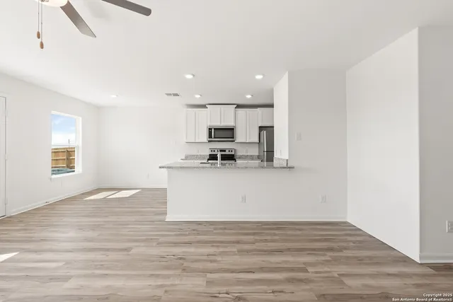 a view of kitchen with granite countertop cabinets and wooden floor