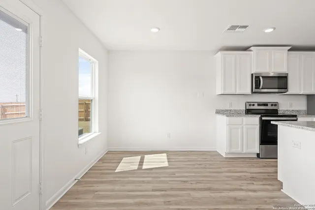 a kitchen with a refrigerator and a stove top oven