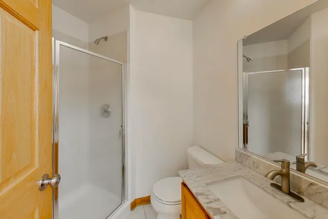 a bathroom with a granite countertop sink toilet and shower
