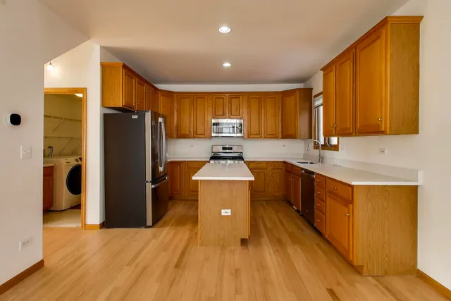 a kitchen with a refrigerator sink and wooden cabinets