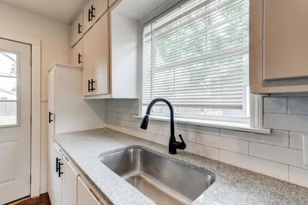 a kitchen with stainless steel appliances sink a window and refrigerator