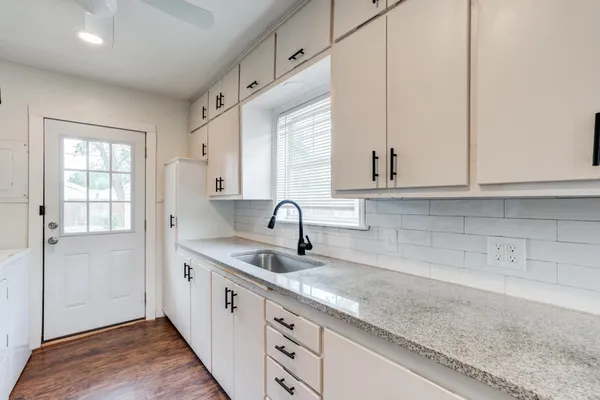 a kitchen with stainless steel appliances granite countertop white cabinets and window
