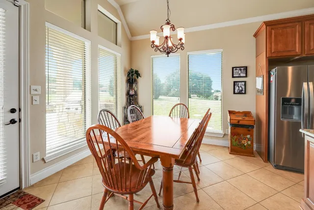 a dining room with furniture a chandelier and wooden floor