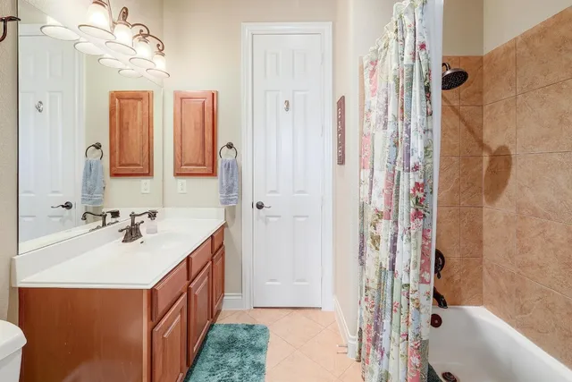 a bathroom with a sink a toilet a mirror and shower