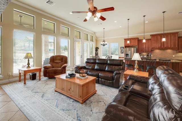 a living room with furniture ceiling fan and a large window
