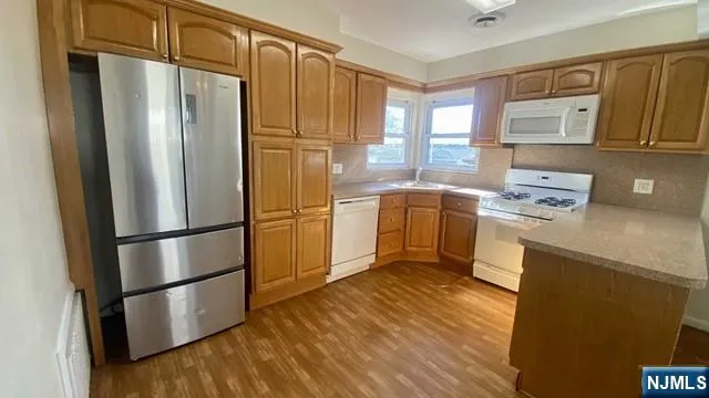 a kitchen with stainless steel appliances a refrigerator a sink a stove a microwave and cabinetry