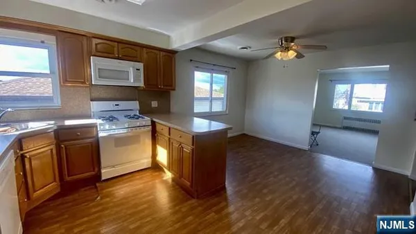 a kitchen with granite countertop wooden floors and stainless steel appliances