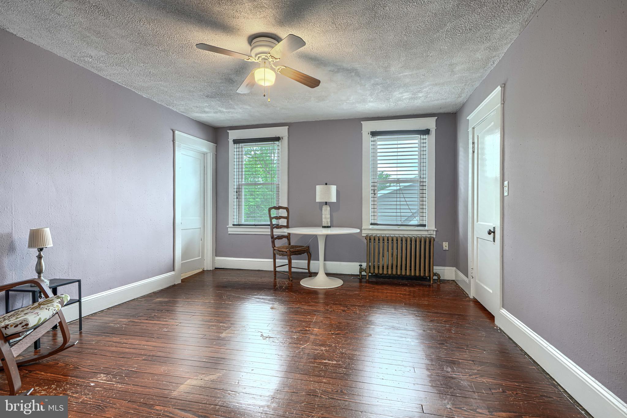 2705 Latona Road Baltimore, MD 21214 - Photo 34 of 53 a living room with couches chairs and a potted plant with wooden floor