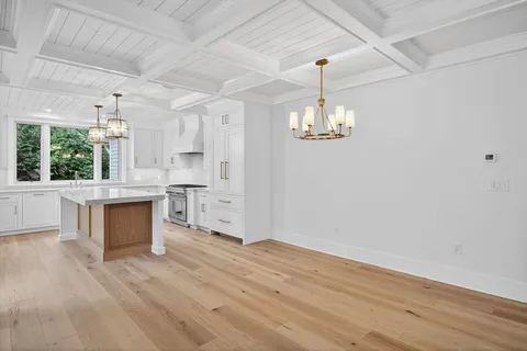 a room with kitchen island white cabinets and wooden floor