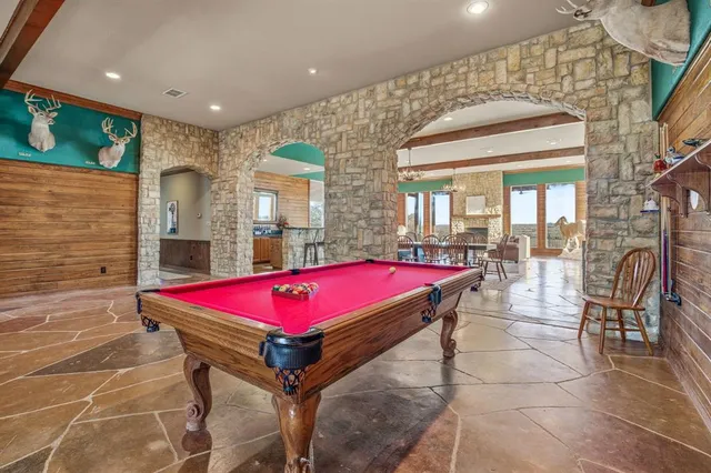 a hall with pool table and chairs