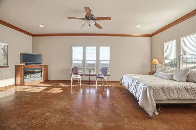 a spacious bedroom with a bed a chandelier and a flat screen tv